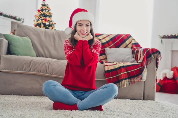 Zdjęcie urocze piękne Santa lady siedzieć podłogi cieszyć atmosferę nosić kapelusz pullover w urządzone x-mas domu w pomieszczeniach — Zdjęcie stockowe