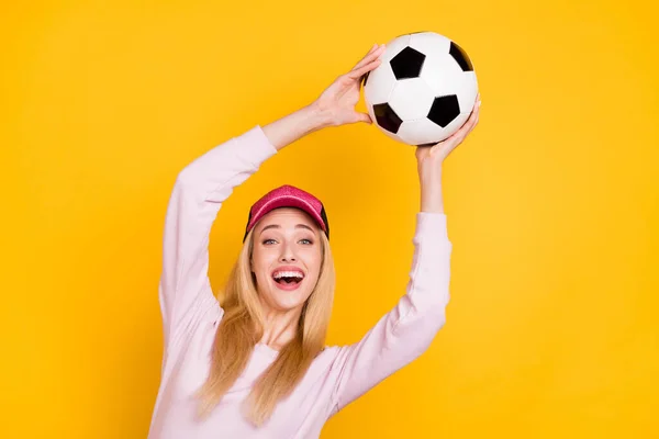 Foto retrato mulher maravilhada em cap captura bola de futebol rindo isolado cor amarela brilhante fundo — Fotografia de Stock