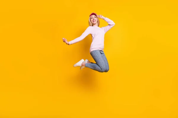 魅力的な屈託のない若い女性の写真はピンクのセーターの頭を身に着けている笑顔ジャンプ高い孤立した黄色の背景 — ストック写真