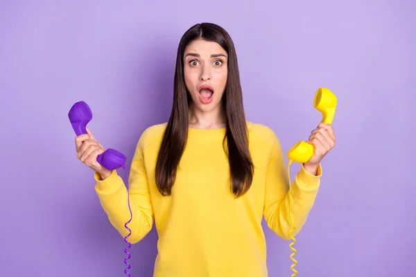 Photo de choqué malheureux jeune femme tenir les mains téléphones fil ligne étonné isolé sur fond de couleur violette — Photo