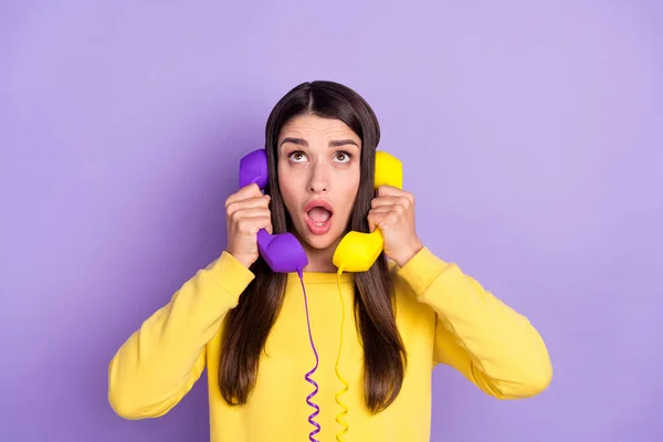 Mor menekşe rengi arka planda izole edilmiş iki cep telefonu konuşan endişeli kızın portresi. — Stok fotoğraf