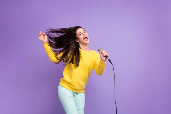明るい若い幸せな女性の写真飛ぶ髪を保持マイク歌手は紫の色の背景に隔離 — ストック写真