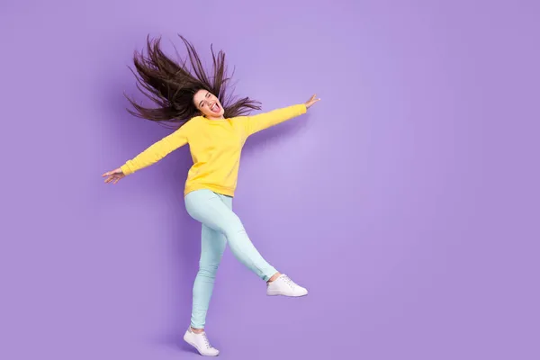 Volledige lengte foto van vrolijke jonge vrolijke vrouw verhogen handen lopen wind blazen haar geïsoleerd op paarse kleur achtergrond — Stockfoto