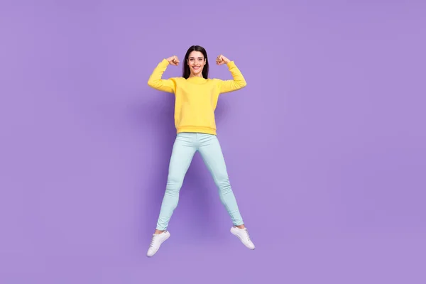 Plná délka tělo velikost pohled na atraktivní veselá dívka skákání ukazuje silné svaly izolované přes fialové fialové barvy pozadí — Stock fotografie