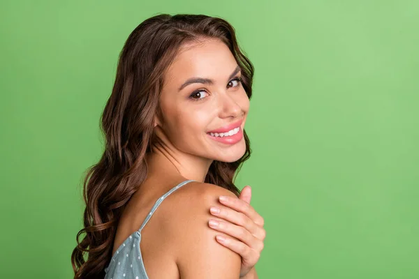 Photo de jeune femme joyeuse positive tenir épaule soins du corps beauté isolé sur fond de couleur verte — Photo