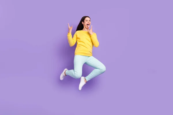 Full längd kroppsstorlek bild av attraktiv glad galen flicka hoppning visar horn tecken grimacing isolerad över violett lila färg bakgrund — Stockfoto