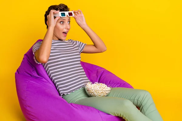 Foto av hurra ung dam sitta titta på film hålla popcorn slitage t-shirt jeans isolerad på gul bakgrund — Stockfoto