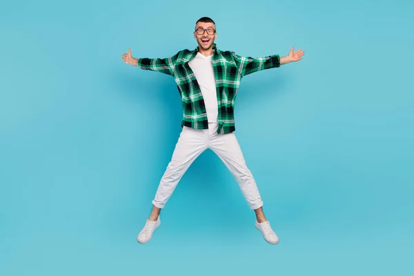 Foto de cuerpo completo de feliz fresco alegre hombre salto estrella forma volar buen humor disfrutar aislado sobre fondo de color azul —  Fotos de Stock
