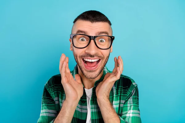 Foto de sorprendido hombre feliz cogido de la mano cara noticias desgaste gafas aisladas sobre fondo de color azul —  Fotos de Stock