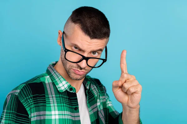 Foto van jonge ongelukkige man wijzen vinger waarschuwing regel slecht humeur slijtage bril geïsoleerd op blauwe kleur achtergrond — Stockfoto