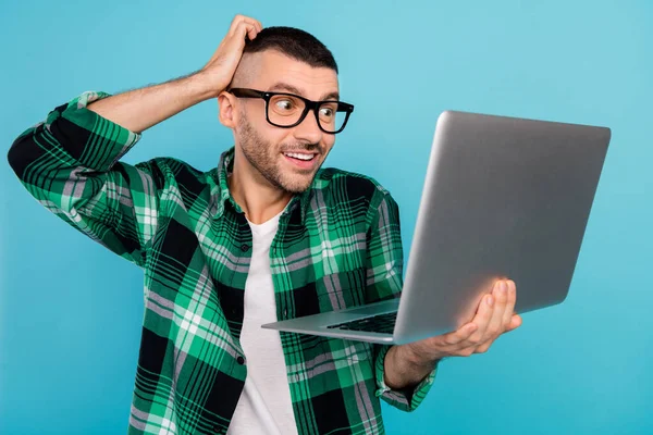 Foto de homem feliz alegre espantado segurar computador olhar tela trabalho programador isolado no fundo de cor azul — Fotografia de Stock