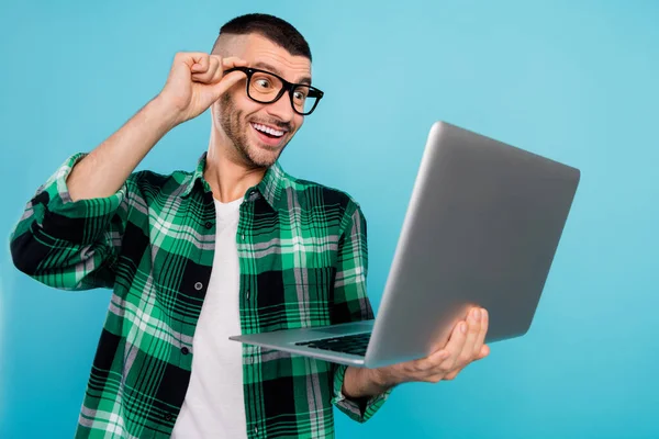 Foto de homem feliz animado espantado olhar segurar mão laptop notícias bom humor isolado no fundo de cor azul — Fotografia de Stock