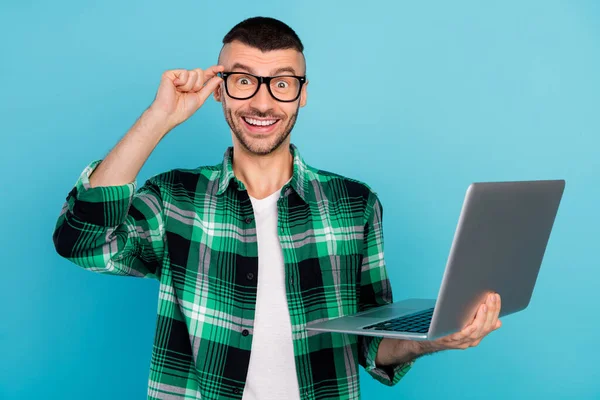 Φωτογραφία του χαρούμενου χαρούμενος έκπληκτος άνθρωπος κρατήστε τα χέρια προγραμματιστής laptop φορούν γυαλιά που απομονώνονται σε μπλε φόντο χρώμα — Φωτογραφία Αρχείου