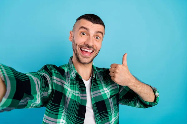 Photo de joyeux homme fou heureux faire selfie montrer pouce vers le haut sourire profiter isolé sur fond de couleur bleue — Photo
