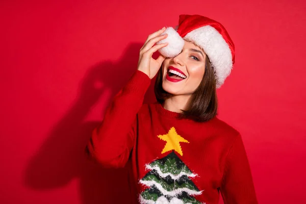 Фото схвильованої кокетливої молодої леді, одягненої в принт пуловер головний убір Пом-поп покриває око святкування нового року ізольованого червоного кольору фону — стокове фото