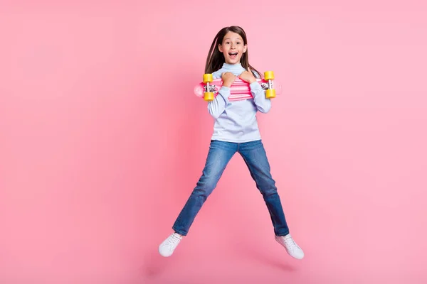 Pełna długość ciała rozmiar widok dość wesoły dziewczyna skoków przytulanie skate zabawy izolowane nad różowy kolor tła — Zdjęcie stockowe