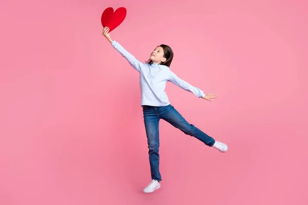 Tamanho do corpo de comprimento total vista de menina muito alegre pulando segurando forma do coração 14 Fevereiro isolado sobre fundo cor-de-rosa — Fotografia de Stock