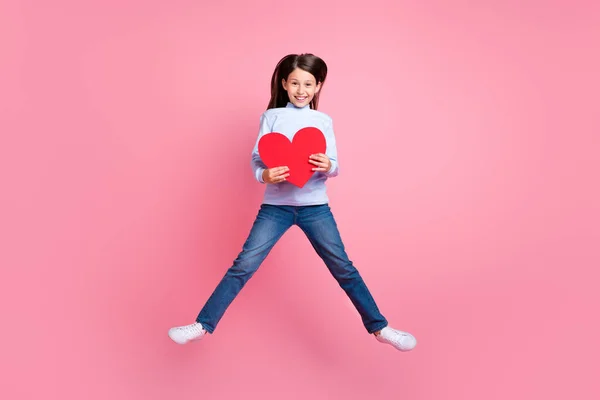 Comprimento total tamanho do corpo vista de menina na moda alegre atraente pulando segurando coração isolado sobre fundo de cor rosa — Fotografia de Stock