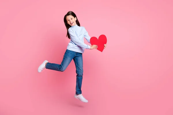 Plná délka tělo velikost pohled na hezké veselá dívka skákání podpírání karty srdce láska izolované přes růžové pastelové barvy pozadí — Stock fotografie