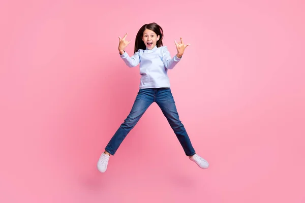 Full length body size view of pretty wesoły cool girl jumping having fun pokazując róg izolowany na różowy pastelowy kolor tła — Zdjęcie stockowe