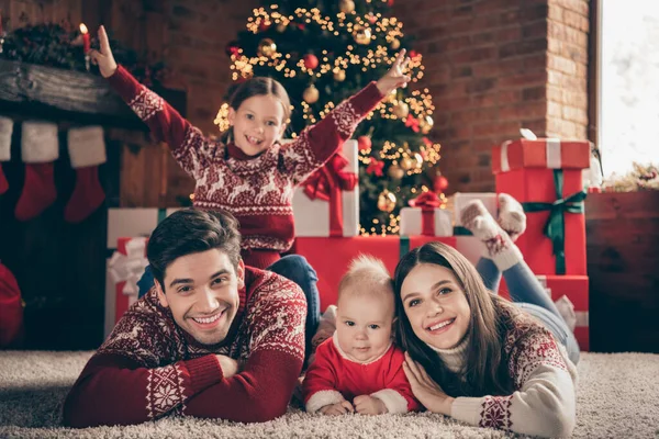 Фото четырех человек имеют Ноэль весело лежа пол наслаждаться чудо сон носить свитер в украшенном дома Рождество в помещении — стоковое фото