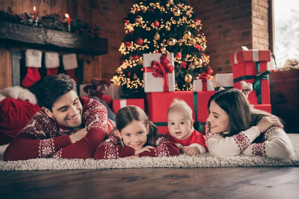 Фото четырех человек семьи наслаждаются связыванием Ноэль накануне подготовки носить свитер в украшенном дома Рождество в помещении — стоковое фото