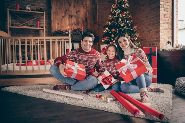 Полная длина фото прекрасной мамы папа дочь сын сидеть держать подарок носить красные носки свитер джинсы в гостиной — стоковое фото
