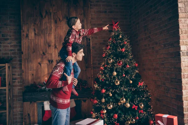 İki kişinin fotoğrafı. Aile babası küçük kızın omuzlarını tutuyor. Yıldız ağacı asıyor. — Stok fotoğraf