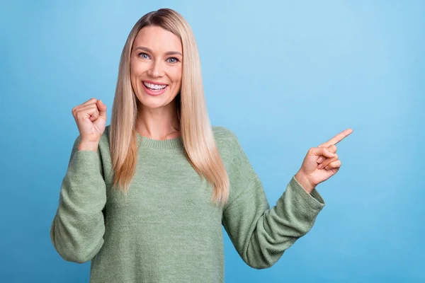 Foto av mogen vacker kvinna glädja framgång nävar hand peka finger tomt utrymme annons promo isolerad över blå färg bakgrund — Stockfoto