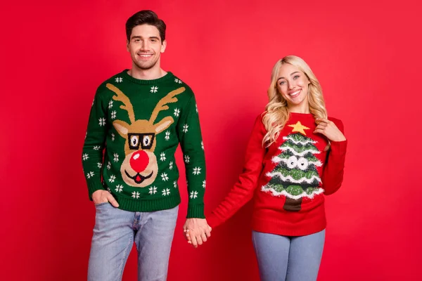 Photo of peaceful serene glad couple hold hands wear ugly ornament pullover isolated red color background — Stock Photo, Image