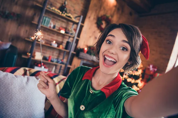 Photo of crazy excited lady hold bengal fire make selfie open mouth wear elf costume in decorated home indoors