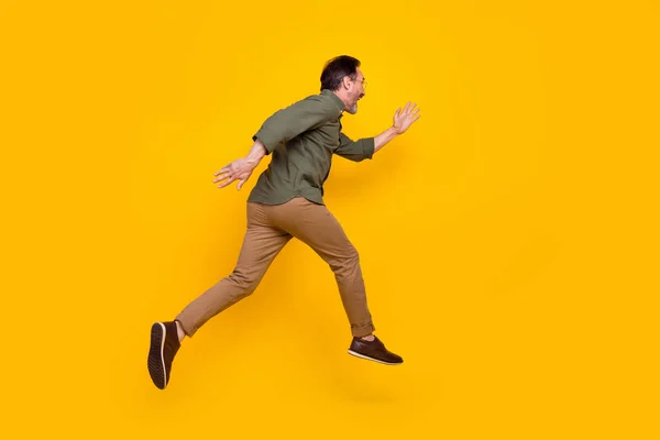 Full length body size profile side view of attractive cheerful man running fast isolated over bright yellow color background — Zdjęcie stockowe