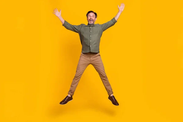 Full längd kroppsstorlek bild av attraktiv lycklig man hoppa ha kul isolerad över levande gul färg bakgrund — Stockfoto