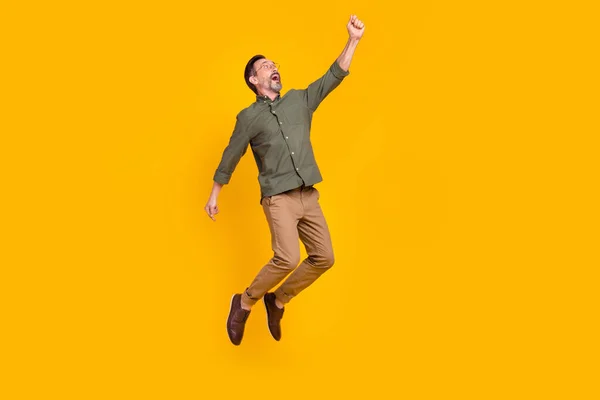 Повнометражний вигляд тіла привабливого веселого чоловіка, який стрибає висить ізольовано на яскраво-жовтому кольоровому фоні — стокове фото