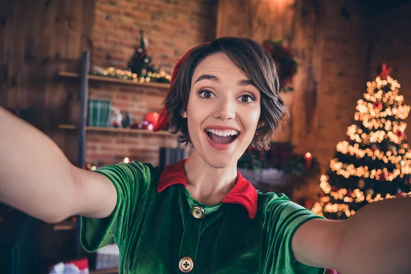 Foto de jovem alegre mulher chocada elfo segurar as mãos câmera fazer selfie xmas férias dentro de casa casa — Fotografia de Stock