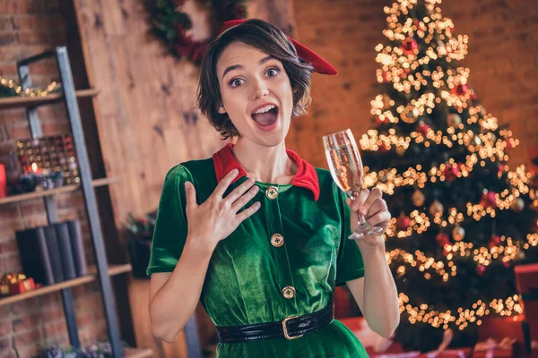Foto de encantador saído jovem senhora usar roupas de elfo beber vinho celebrando o Natal sorrindo dentro de casa casa casa quarto — Fotografia de Stock