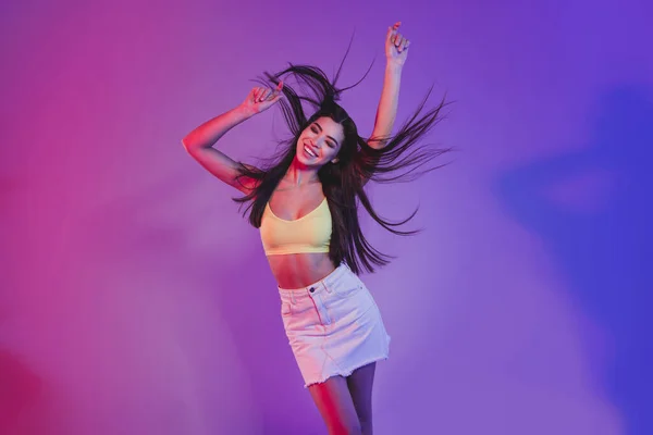Retrato de atractiva chica de ensueño alegre bailando posando frío aislado sobre vívido violeta púrpura neón color fondo — Foto de Stock