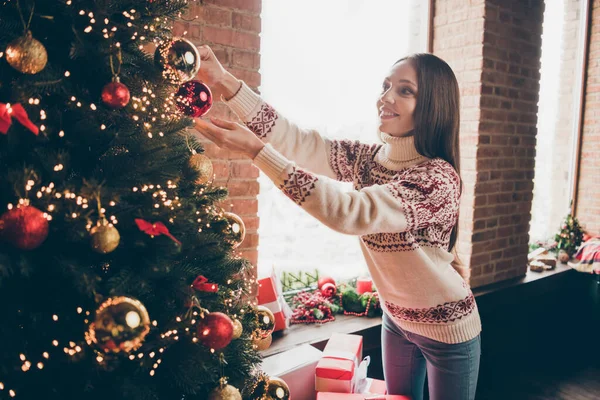 Foto de encantadora mulher madura brilhante usar camisola impressão sorrindo decorar árvore de Natal dentro de casa casa quarto — Fotografia de Stock