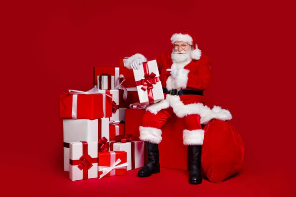 Fotografie funky roztomilý muž důchodce oblečený Santa Claus kostým ukazující prstem představuje usmívající se izolované červené barvy pozadí — Stock fotografie