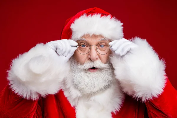 Foto de funky impressionado homem aposentado vestido santa claus fantasia braços óculos olhos grandes isolado cor vermelha fundo — Fotografia de Stock