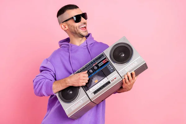 Fotografie mladého veselého chlapa těšit hudební rytmus retro boombox brýle izolované přes růžové barvy pozadí — Stock fotografie