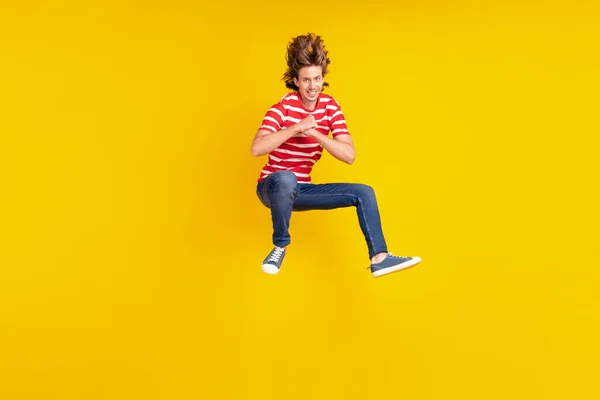 Teljes hosszúságú testméret kilátás vonzó vidám srác jumping szórakozás jó hangulat elszigetelt felett ragyog sárga színű háttér — Stock Fotó