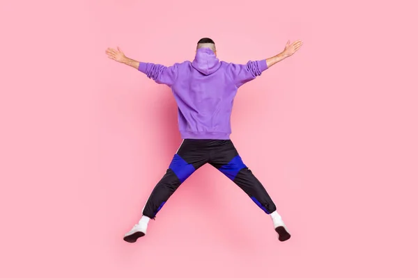 Atrás vista trasera foto de tamaño completo del joven hombre anónimo volar salto deportivo aislado sobre fondo de color rosa — Foto de Stock