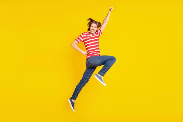 Foto van zoete charmante jonge man gekleed rood t-shirt springen hoog glimlachen geïsoleerde gele kleur achtergrond — Stockfoto