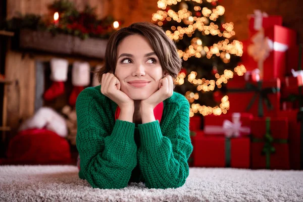 Foto van opgewonden dromerige jonge vrouw gekleed gebreide trui zittende armen wangen glimlachen binnen kamer huis — Stockfoto