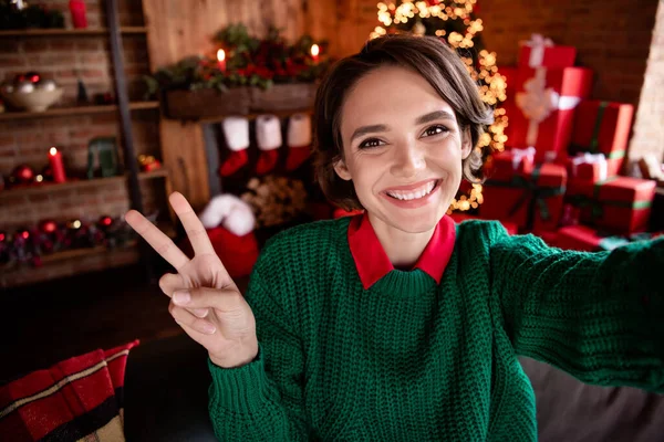 Foto de senhora amigável tirar selfie show v-sign radiante sorriso desgaste verde pulôver de malha em casa decorada dentro de casa — Fotografia de Stock