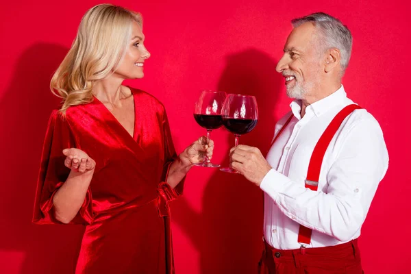 Perfil da foto lateral do marido maduro e da esposa beber álcool comemorar aniversário isolado sobre fundo de cor vermelha — Fotografia de Stock