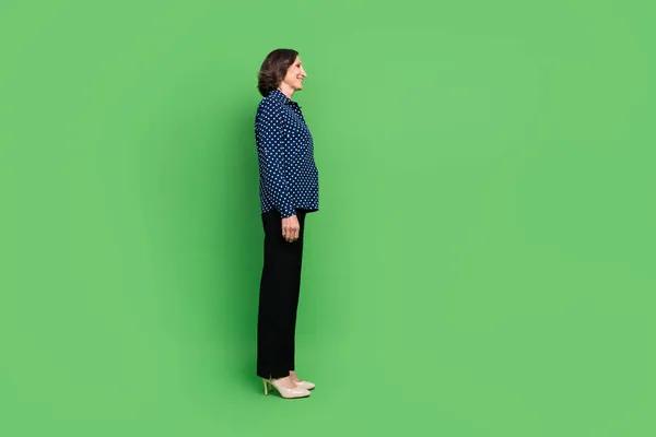 Foto lengkap wanita tua mengenakan celana kaos sepatu hak tinggi terisolasi pada latar belakang warna hijau — Stok Foto