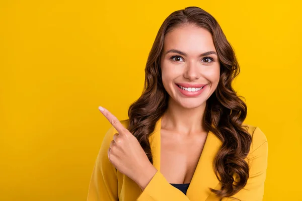 Retrato de mulher alegre de cabelos ondulados atraente demonstrando cópia ideia espaço anúncio isolado sobre fundo de cor amarelo brilhante — Fotografia de Stock
