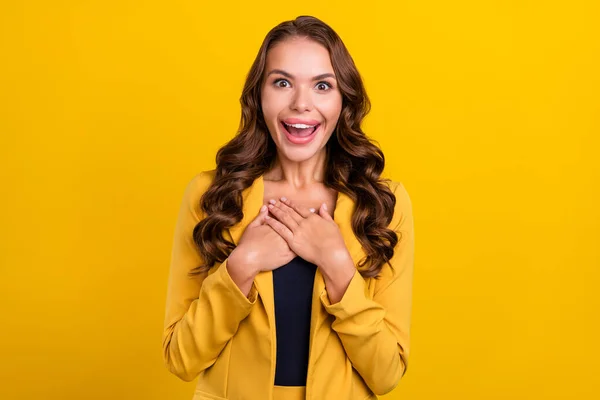 Porträtt av attraktiva glada förvånad vågigt hår kvinna njuter av goda nyheter isolerade över ljusa gula färg bakgrund — Stockfoto